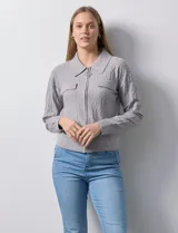Cardigan gris en tejido jacquard, con cuello con solapa y abertura central con cierre. Delantera con bolsillos simulados.