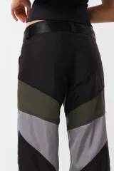 Pantalón negro de corte recto y tiro medio, con recortes en las piernas con detalle de vivo. Cintura con presillas y cinto correa con broche plástico incluido.