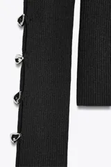 Top ajustado de punto acanalado color negro, de cuello redondo y manga larga con aberturas y botones metálicos en los brazos.
