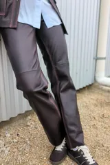 Pantalón de cuero marrón, de corte jeanero y piernas rectas.