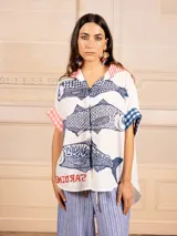 Camisa oversize blanca con estampado de sardinas azules en el frente y la palabra "amore" en la espalda. Detalles de estampa vichy en mangas y rayas en el cuello.