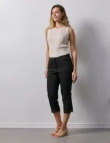 Pantalón capri negro de algodón con terminación de ruedo con aplique calado.