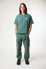 Remera de manga corta color gris oscuro, con cuello redondo y un pequeño parche cuadrado con una 'X' estampada en el pecho izquierdo.