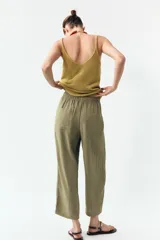 Pantalón color verde oliva de tiro alto, corte ancho y largo 7/8. Tiene cintura elástica ajustable con cordón, bolsillos de plastrón en delantero y espalda.