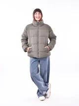 Campera puffer color gris topo, con cuello alto y cierre frontal.