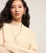 Sweater negro de punto con cuello redondo, puños y ruedo acanalados. Incluye cuello, puños y ruedo de camisa celeste a rayas.