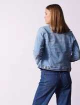 Campera de jean celeste, marca Baccini, con cuello solapa, bolsillos delanteros y cierre frontal con botones metálicos.