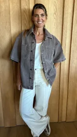 Sobrecamisa color gris oscuro de denim suave, con cuello clásico, cierre frontal con botones, mangas cortas y dos bolsillos de parche en el pecho.