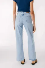 Pantalón jean celeste de corte recto, con cintura alta y etiqueta de cuero marrón con logo en la parte trasera.