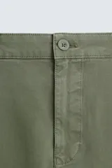 Pantalón chino color beige, corte skinny fit, confeccionado en tejido con mezcla de algodón y elasticidad. Cuenta con bolsillos frontales y traseros. Cierre frontal con cremallera y botón.