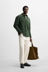 Camisa azul marino de algodón con textura jacquard, corte relaxed fit, cuello solapa, manga larga con puños abotonados y cierre frontal con botones.