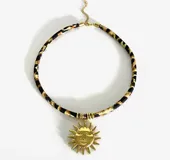 Gargantilla con cordón estampado animal print y dijes dorados con diferentes motivos: concha, sol, corazón, golondrina, pez y palmera.
