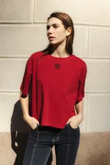 Remera negra de algodón con corte cuadrado, cuello redondo y logo bordado en color naranja.