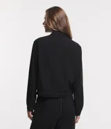 Campera bomber negra de viscosa con cierre delantero, bolsillos con solapa y pespuntes contrastantes en color blanco.