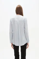 Blusa de viscosa con cuello mao y abertura frontal con botones. Presenta un estampado de rayas verticales finas en tonos azul claro, blanco, marrón y azul oscuro.