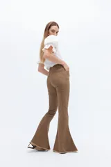 Pantalón de jean acampanado color marrón, con tiro alto y alforza central.
