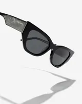 Gafas de sol unisex Hawkers modelo Manhattan, con montura negra y lentes grises.