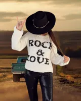 Sweater tejido a mano en lana merino color crudo, con diseño de texto 'Rock & Love' en lana negra teñida a mano en el frente y espalda lisa.