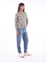 Sweater color beige con estampado de leopardo, cuello redondo y mangas largas.