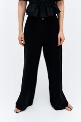 Pantalón negro de lino, de tiro alto, corte ancho y bolsillos laterales.