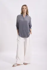 Camisa gris de corte holgado, con cuello clásico y mangas 3/4.