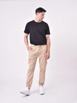 Pantalón jogger gris oscuro con cintura elástica ajustable con cordón, bolsillos laterales y bolsillo cargo con solapa en la pierna. Puños elásticos en los tobillos.
