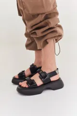 Sandalias de diseño con tiras anchas, combinando colores beige y negro, con plataforma cómoda.