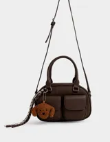 Cartera bowling marrón chocolate de cuerina con doble bolsillo frontal con solapa y broche, cierre superior, correa regulable y desmontable, manijas superiores y charm de perrito.