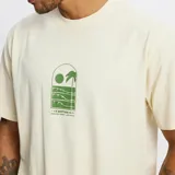 Remera color crema con estampado en el frente de una escena de playa con palmera, sol y olas.