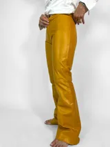 Pantalón de cuero color mostaza, de corte con piernas anchas y tiro medio alto. Fabricado en Uruguay.