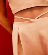 Pantalón jogger color beige de satín, con cintura elástica y lazos ajustables en los tobillos.