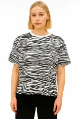 Remera blanca con estampado de líneas onduladas negras, de manga corta, corte holgado y cuello redondo.