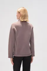 Campera color lila de micropolar con cuello alto, cierre frontal y bolsillos laterales.