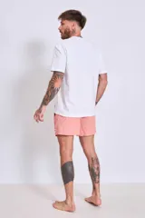 Short de baño color marrón con cordón ajustable en la cintura y logo estampado en blanco en la pierna izquierda.