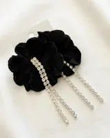Par de caravanas negras con forma de flor y strass colgantes.