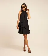 Vestido corto negro con escote halter y volados superpuestos en la falda.