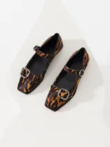 Zapato tipo Mary Jane con estampado animal print, hebilla metálica y taco bajo.