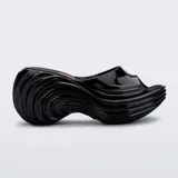 Sandalias Melissa negras de plataforma, colaboración con Diesel, con diseño ondulado y punta descubierta.