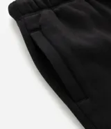 Pantalón baggy color beige, confeccionado en algodón con felpa. Presenta cintura elástica con cordón ajustable, bolsillos delanteros y un bolsillo trasero. El bajo es ajustable con elástico.