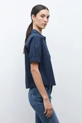 Camisa de vestir color azul marino, con cuello clásico y cierre frontal de botones.