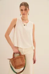 Musculosa blanca de algodón con cuello redondo y sisas amplias.