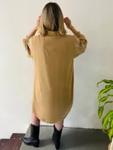 Camisola larga color beige con apliques de strass plateados, cuello camisero, mangas largas con puños abotonados y cierre frontal con botones. Puede usarse como vestido o sobrecamisa.