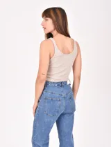 Musculosa corta marrón de morley con breteles finos y estampado de una estrella blanca en el centro.