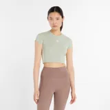 Remera deportiva New Balance modelo Harmony Fitted, color verde claro, de corte ajustado y largo crop. Presenta mangas cortas, cuello redondo y logo de la marca en el pecho.