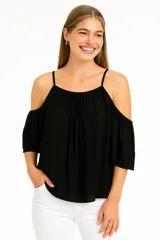 Blusa blanca con breteles finos y hombros descubiertos, corte holgado y escote redondo.
