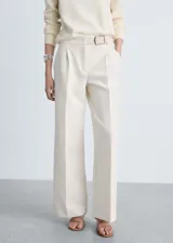 Pantalón de vestir color crema de corte palazzo, con pinzas en la cintura y cinturón fino con hebilla plateada.