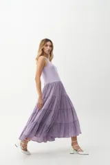 Vestido midi color lila, con cuerpo superior ajustado de punto canalé y falda amplia de tres niveles con textura arrugada.