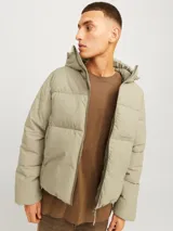 Campera puffer color beige con capucha ajustable, cierre de cremallera, bolsillos frontales y puños acanalados.