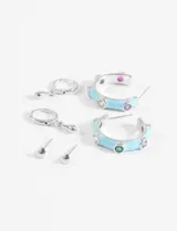 Set de aros plateados que incluye un par de aros tipo argolla con colgante de gota, un par de aros tipo arito con forma de corazón y un par de aros tipo argolla con esmalte celeste y strass de colores.