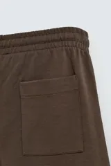 Bermuda azul de corte relaxed fit, confeccionada en tejido interlock de algodón con cintura elástica ajustable con cordón, bolsillos laterales y bolsillo trasero de plastrón.